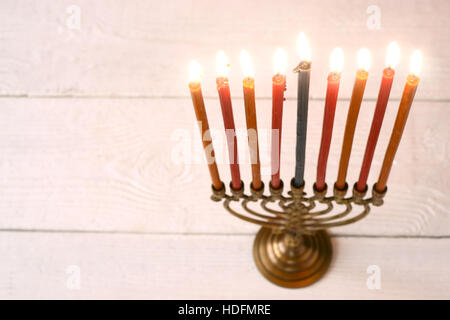 Hanukkah menorah avec bougies allumées sur la table horizontale en bois blanc Banque D'Images