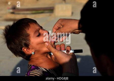 Kandahar, Afghanistan. Dec 12, 2016. Un enfant afghan reçoit un vaccin contre la polio au cours d'une campagne anti-polio dans la province de Kandahar, Afghanistan, le 12 décembre 2016. Une campagne anti-polio a commencé dans le sud de la province de Kandahar, le lundi. Credit : Sanaullah Saiem/Xinhua/Alamy Live News Banque D'Images