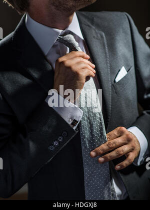 Close-up of sharp dressed man ajustant sa cravate. Banque D'Images