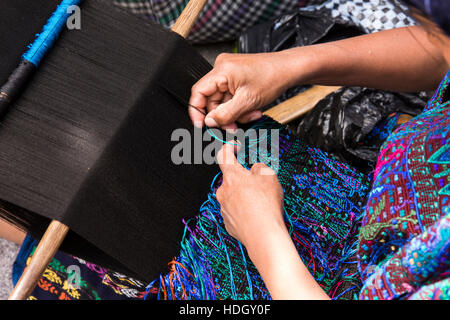 Les femmes mayas assis sur le sol et à l'aide de métiers à tisser en vêtements traditionnels à Santa Catarina Palopo, Guatemala. Banque D'Images