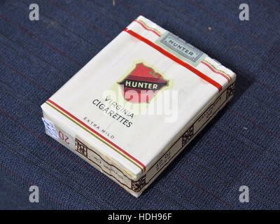 L'image représente un paquet de cigarettes Hunter, un produit connu pour sa marque sur le marché concurrentiel de la cigarette. Le pack reflète les tendances de conception et les styles de marketing du milieu du XXe siècle dans l'industrie du tabac. Banque D'Images
