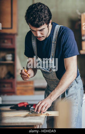 Carpenter marquage sur bois avec crayon et règle à l'atelier Banque D'Images