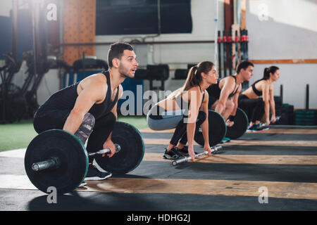 Des athlètes masculins et féminins des barres de levage at gym Banque D'Images