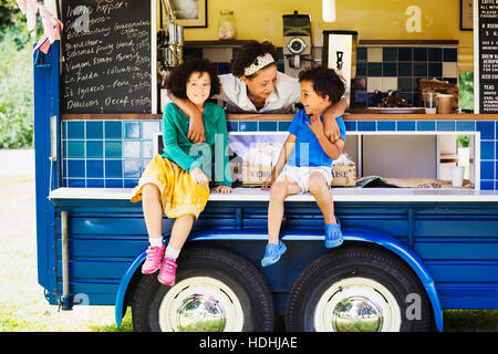 Garçon et fille assise sur le comptoir d'un café. Banque D'Images