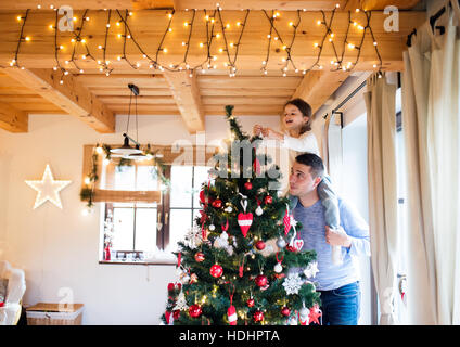 Jeune père avec daugter decorating Christmas Tree ensemble. Banque D'Images