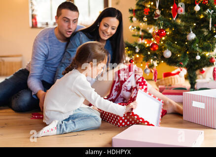 Jeune famille avec daugter à arbre de Noël à la maison. Banque D'Images