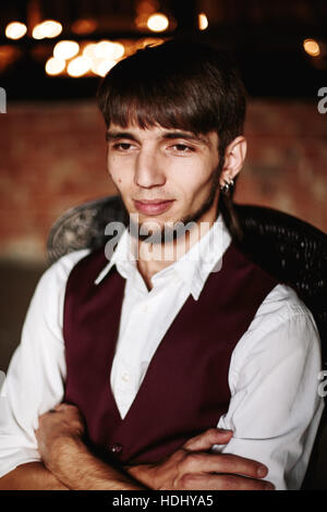 Certain homme authentique barbu assis sur une chaise, close-up portrait Banque D'Images