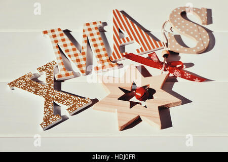 Certains des différentes lettres formant le mot noël et une étoile de Noël en bois, sur une surface blanche Banque D'Images
