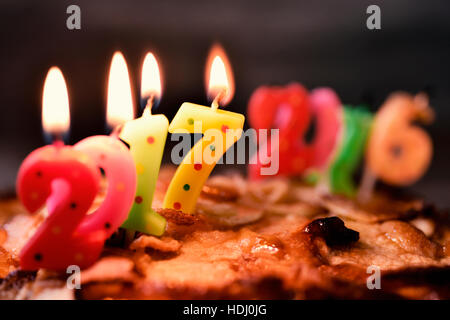 Allumé quatre bougies en forme de nombre de couleurs différentes formant le nombre 2017, comme la nouvelle année, sur un gâteau, et plus le burn-out et fait fondre des bougies formant t Banque D'Images