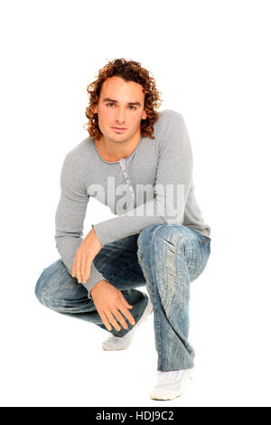 Jeune homme posant sur un studio isolé sur fond blanc Banque D'Images