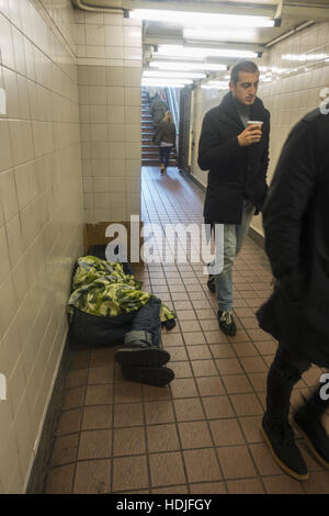 Homme sans foyer qui peut accueillir une apparence inaperçu en entrée de la station de métro au centre de Manhattan, New York. Banque D'Images