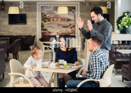 La famille, la parentalité, la technologie, les gens heureux concept - mère, père et petite fille qui a demandé à prendre une photo par serveur smartphone Blackberry Banque D'Images