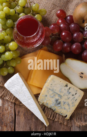 Fromage moulé, du vin et des fruits sur la table, close-up. Vue verticale d'en haut Banque D'Images