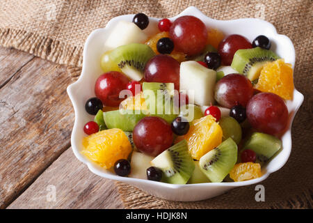 Salade de fruits d'oranges, poires, raisins. kiwis dans un bol blanc libre horizontale. Banque D'Images
