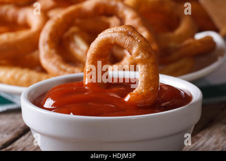 Oignon frit avec du ketchup macro. horizontal, style rustique Banque D'Images