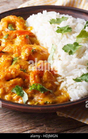 Crevettes au curry sauce avec le riz et la coriandre gros plan sur une plaque verticale. Banque D'Images