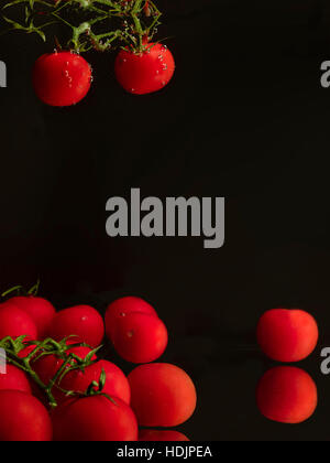 Tomates cerises en arrière-plan sombre. Banque D'Images