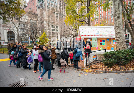 Les mères et les bonnes d'avec leurs enfants jusqu'à la ligne entre le goût de l'accueil gingerbread house on 'Gingerbread Blvd' dans Madison Square Park, à New York le Mercredi, Décembre 7, 2016. L'affichage interactif a été créé par goût de l'accueil magazine qui publie des recettes et astuces de ménage et de cuisiniers à domicile. (© Richard B. Levine) Banque D'Images