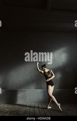 Jeune gymnaste danser dans l'obscurité éclairée prix Banque D'Images