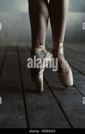 Ballerine debout sur la pointe des pieds dans la chambre noire Banque D'Images