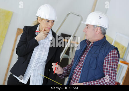 Une femme et un contremaître architecte discuter at construction site Banque D'Images