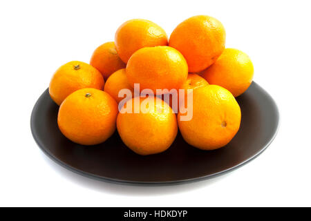 Plaque noire avec mandarines sur un tas Banque D'Images