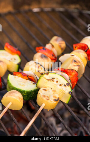 Barbecue végétarien. La cuisson des légumes sur un bâton. Un barbecue avec des aliments sains les courgettes, l'oignon, pomme de terre et poivron rouge sur brochette. Banque D'Images