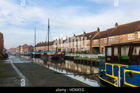 Les chalands amarrés le long de la restauré beck (canal) sur un matin calme, lumineux en automne flanquée de maisons en rangée. Banque D'Images