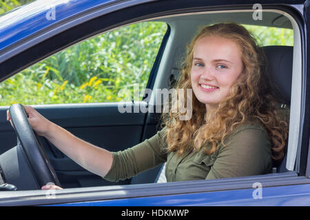 Portrait of young woman holding hollandais volant driving car Banque D'Images