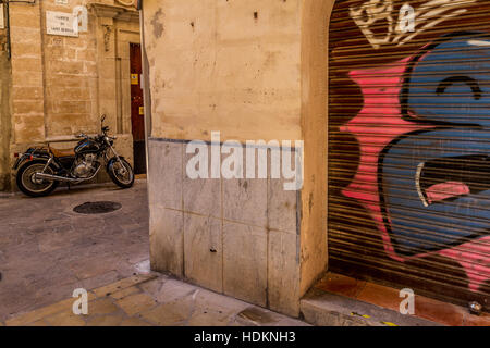 Graffiti sur mur de garage dans quartier calme avec moto style ancien Banque D'Images