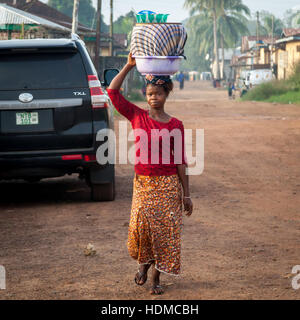 Femme dans la rue de Kenema, Sierra Leone, portant un grand panier sur la tête. Banque D'Images