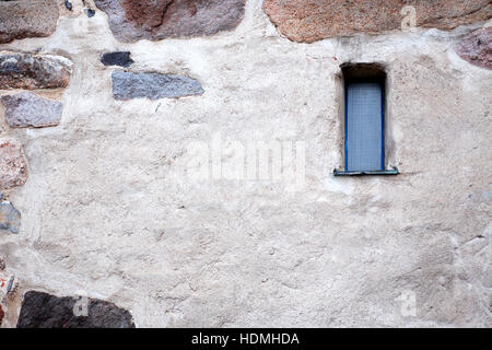 Vieux Mur de pierre avec petite fenêtre étroite. Bon background Banque D'Images