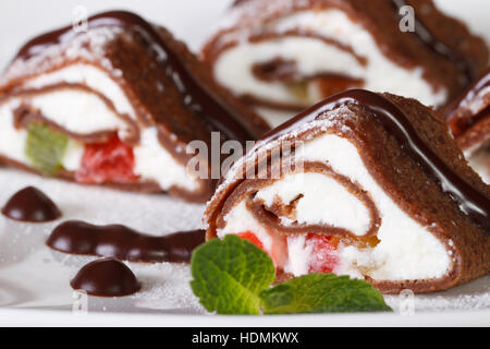 Dessert asiatique : pains au chocolat avec du fromage, des fruits et de menthe sur une assiette blanche horizontale de macro. Banque D'Images