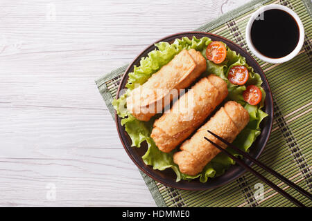 Rouleaux de printemps frits sur une assiette avec salade, vue horizontale d'en haut Banque D'Images