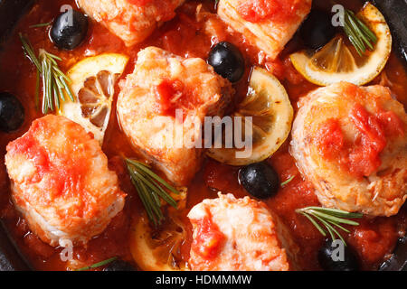 Filet de poisson en sauce tomate avec du citron et des olives macro. vue horizontale d'en haut Banque D'Images