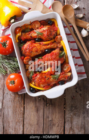 Des cuisses de poulet cuites dans une sauce tomate avec des légumes. vertical Vue de dessus close-up Banque D'Images