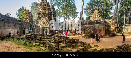 Les touristes visitent le temple antique ruines de Ta Prohm en face de l'Spung des racines d'arbre qui poussent sur les pierres à Siem Reap, Cambodge. Banque D'Images