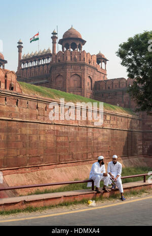 Deux hommes musulmans indiens en costume traditionnel en face de murs de Fort Rouge, Delhi, Inde Banque D'Images