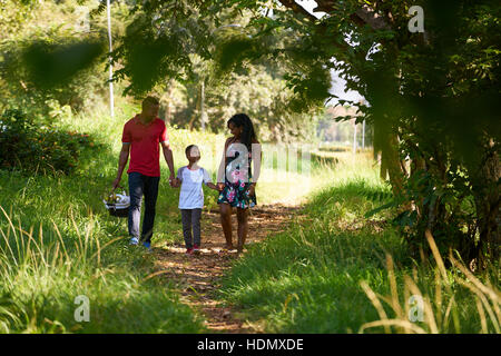 Happy black couple avec fils walking in city park. African American Family avec jeune homme, femme et enfant pique-nique faire, avoir du plaisir en plein air. Banque D'Images