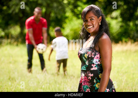 Heureux les noirs en parc. African American Family avec jeune père et fils s'amusant avec le football. Portrait of smiling Banque D'Images