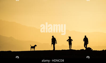 Las Palmas, Gran Canaria, Îles Canaries, Espagne. 14 Décembre, 2016. Météo : Dog Walkers silhouetté au coucher du soleil sur la crête de la montagne près de Las Palmas, la capitale de Gran Canaria. Las Palmas a été nommé récemment comme l'une des "top 10 destinations sur le lieu' par Tripadvisor. Credit : Alan Dawson News/Alamy Live News Banque D'Images