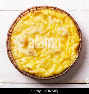 Cocotte avec des pâtes sous une croûte de fromage cottage sur une table en bois Banque D'Images