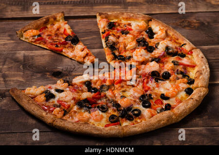 Délicieux avec des fruits de mer pizza italienne servi sur table en bois Banque D'Images