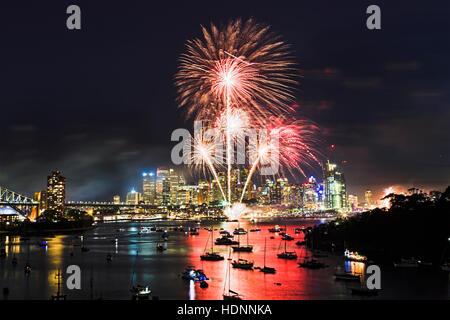 Boule de lumière rouge de plus en plus sur les traces de premier plan au cours d'artifice nouvel an à Sydney CBD sur la ville. Bright light show reflète encore dans les eaux du port abo Banque D'Images