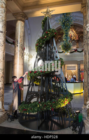 Londres, Royaume-Uni. 5 décembre 2016. Un membre du personnel s'applique la dernière touche à l'arbre. Le V&A Museum dévoilent leurs 2016 arbre de Noël dans la grande entrée à l'occasion des fêtes de fin d'année. Cette année, StudioXAG ont conçu un arbre inspiré par les collections et l'ère victorienne dans laquelle le musée a été fondé. L'arbre comporte des motifs de la V&A toit de fer, et il a été habillé avec des décorations sur mesure, qui rappelle la grande époque victorienne. Banque D'Images