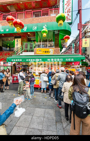 Le Japon, Kobe Nankinmachi, Chinatown. Les gens de la file d'attente à la populaire chinois à emporter, wc séparés avec restaurant ci-dessus. Le printemps, froid, les gens en couches. Banque D'Images