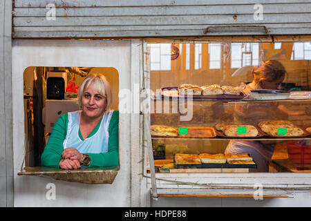 Femme dans la boulangerie regardant par la fenêtre à Tbilissi, Géorgie. Banque D'Images
