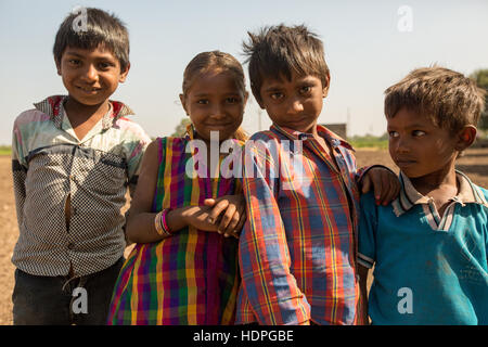 Les travailleurs agricoles enfants attendent leurs familles à fini de travailler pour la journée, la récolte du coton biologique dans le Gujurat, Inde. Banque D'Images