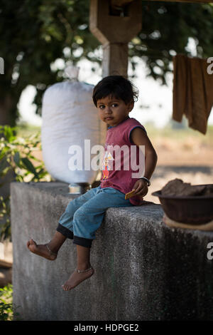 Les travailleurs agricoles enfants attendent leurs familles à fini de travailler pour la journée, la récolte du coton biologique dans le Gujurat, Inde. Banque D'Images