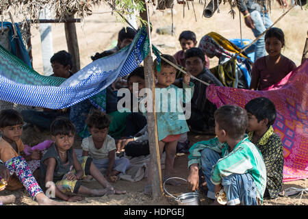 Les travailleurs agricoles enfants attendent leurs familles à fini de travailler pour la journée, la récolte du coton biologique dans le Gujurat, Inde. Banque D'Images